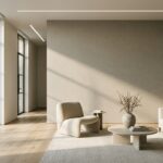 Phòng khách tối giản với sofa màu xám, ghế bành màu kem, bàn trà tròn và cửa kính lớn đón ánh sáng tự nhiên